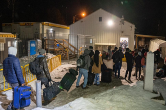 Migrantes procedentes de Nueva York con destino a Canadá en el paso fronterizo de Plattsburg. EFE/Ángel Colmenares
