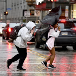 Personas corren en medio de la lluvia en Smithfield St. en Pittsburgh el 29 de abril del 2025. (Sebastian Foltz/Pittsburgh Post-Gazette via AP) (Sebastian Foltz, Pittsburgh Post-Gazette)