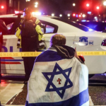 Un hombre con una bandera israelí, frente al lugar donde fueron asesinados dos trabajadores de la embajada de Israel en Washington. Will Oliver/EFE/EPA