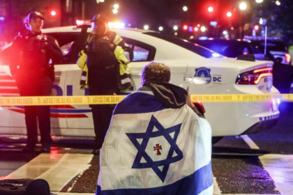 Un hombre con una bandera israelí, frente al lugar donde fueron asesinados dos trabajadores de la embajada de Israel en Washington. Will Oliver/EFE/EPA