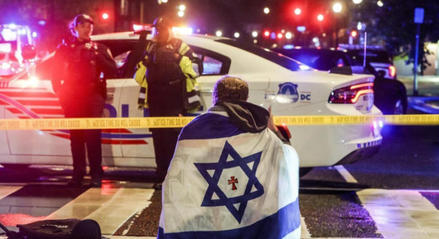 Un hombre con una bandera israelí, frente al lugar donde fueron asesinados dos trabajadores de la embajada de Israel en Washington. Will Oliver/EFE/EPA