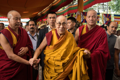 Flanked by Buddhist monks, the Dalai Lama, 84, greets visitors in September at a prayer ceremony at his monastery in Dharamsala, India. NPR