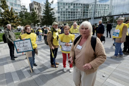 Fotografía extraída de Yahoo! Noticias . La activista y cofundadora del grupo proeutanasia Ultime Liberté, Claude Hurry (centro), llega al juicio en su contra en París, acompañada de simpatizantes, el 15 de septiembre de 2025. (STEPHANE DE SAKUTIN) STEPHANE DE SAKUTIN/AFP/AFP