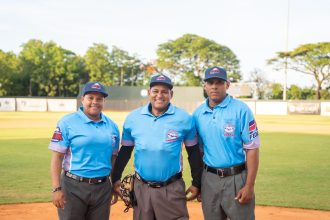 A la izquierda, Omairy Guzmán, momentos antes de convertirse en la primera mujer en arbitrar en la pelota profesional dominicana.